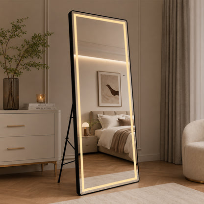 Helfigur spejl med LED-lys og sort ramme 65x165 cm står tændt på gulvstativ i soveværelse